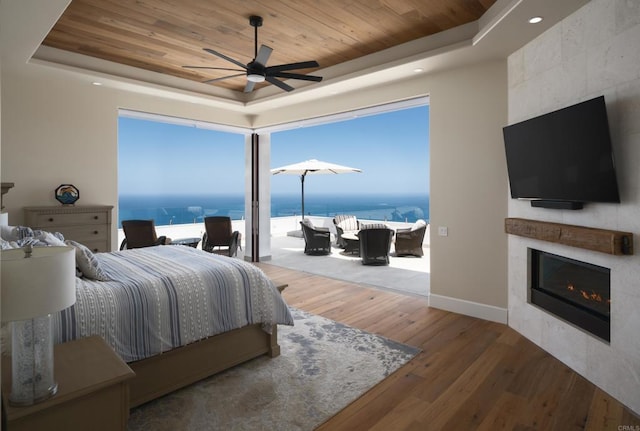 211 Mar De Cortez, Avalon, CA 90704 - bedroom featuring a raised ceiling, wooden ceiling, wood finished floors, a large fireplace, and floor to ceiling windows