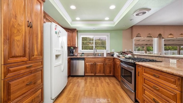860 Knollwood Dr, Corona, CA 92882 - kitchen featuring appliances with stainless steel finishes, brown cabinetry, a raised ceiling, light wood-type flooring, and crown molding