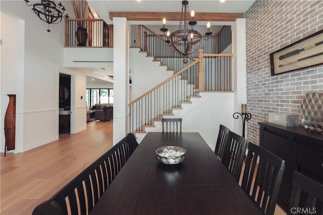 5225 Topeka Dr, Tarzana, CA 91356 - dining space with a chandelier, wood finished floors, stairs, brick wall, and beamed ceiling