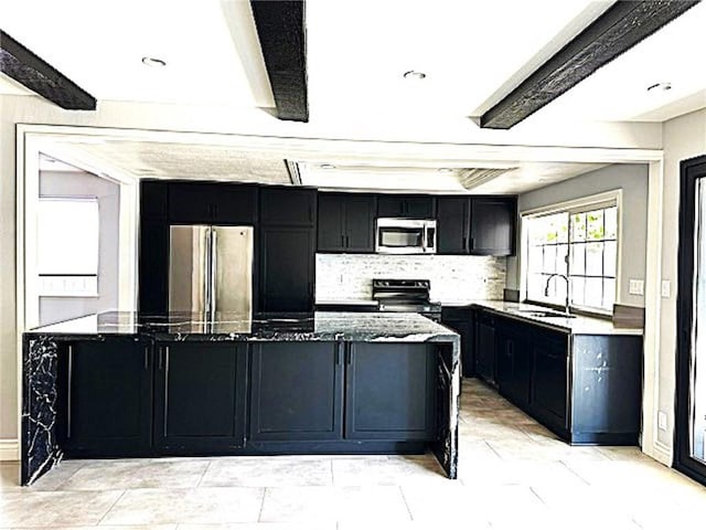 1063 Redding Ave, Costa Mesa, CA 92626 - kitchen with appliances with stainless steel finishes, dark cabinetry, dark stone countertops, beam ceiling, and tasteful backsplash