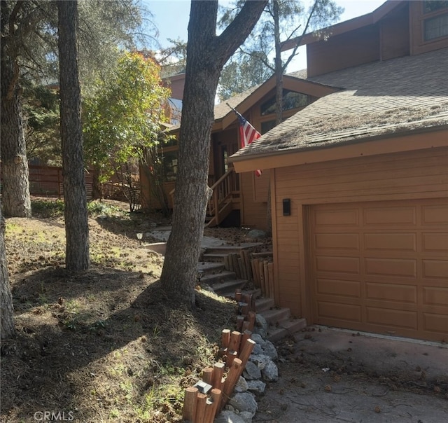 2701 Hillcrest Ct, Frazier Park, CA 93225 - view of side of home with stairs, a shingled roof, and a garage