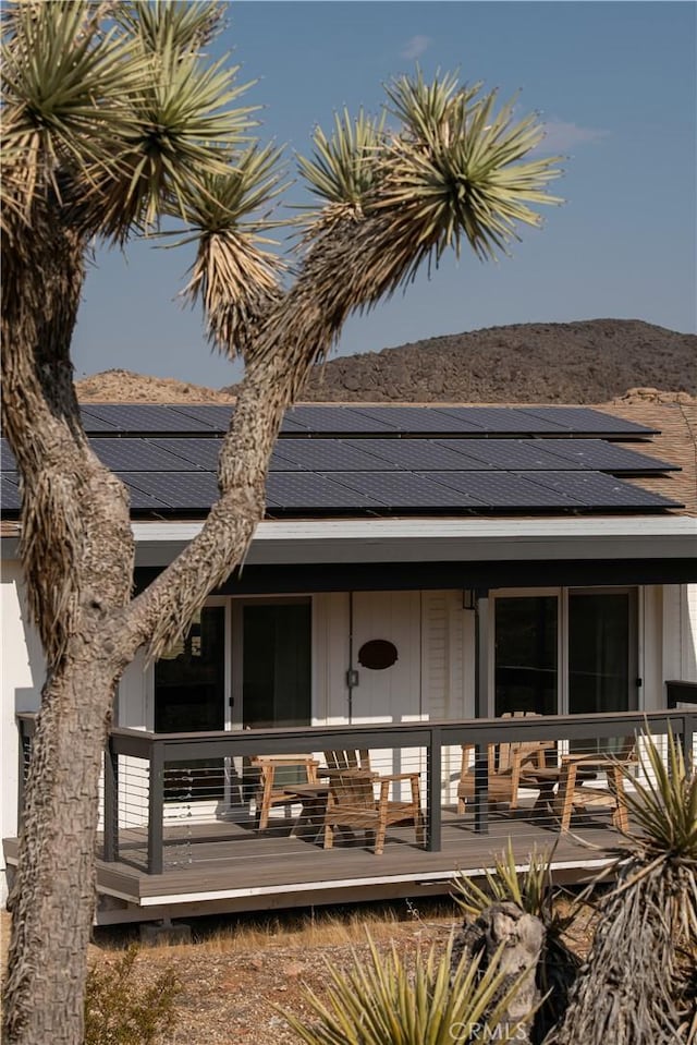 59855 Security Dr, Yucca Valley, CA 92284 - rear view of property with solar panels, a mountain view, and a shingled roof