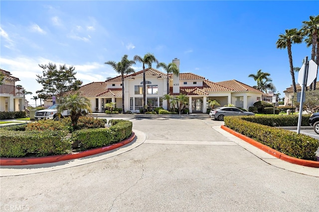 405 Ribbon Beach Way Unit 243, Oceanside, CA 92058 - view of front of house featuring uncovered parking, a tile roof, stucco siding, a chimney, and a residential view