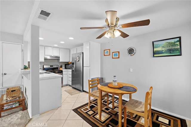 405 Ribbon Beach Way Unit 243, Oceanside, CA 92058 - kitchen featuring stainless steel appliances, under cabinet range hood, tile counters, light tile patterned floors, and ceiling fan