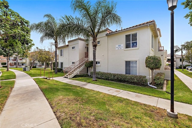 405 Ribbon Beach Way Unit 243, Oceanside, CA 92058 - view of front of home featuring a front lawn, stucco siding, a tile roof, stairs, and a residential view