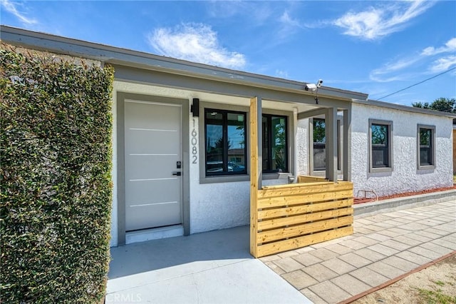 16082 Athol St, Fontana, CA 92335 - doorway to property featuring a porch and stucco siding
