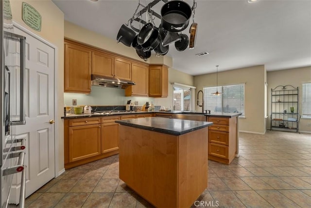 2631 Harvest Crest Ln, Corona, CA 92881 - kitchen featuring a peninsula, under cabinet range hood, a kitchen island, tile patterned flooring, and pendant lighting