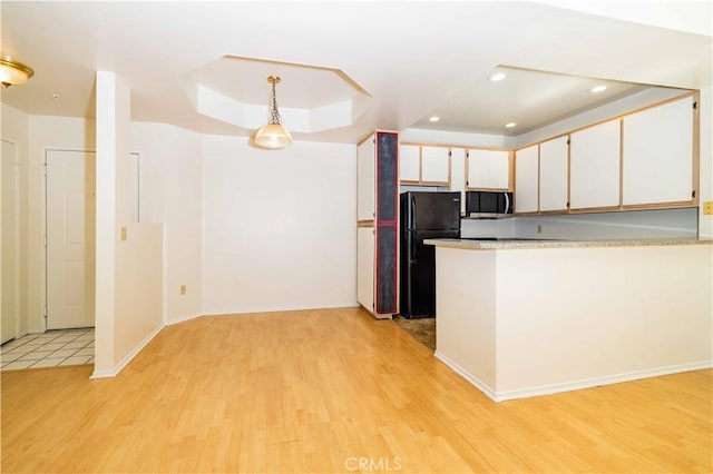 640 W 4th St Unit 308, Long Beach, CA 90802 - kitchen with freestanding refrigerator, light wood-type flooring, light countertops, white cabinetry, and a raised ceiling