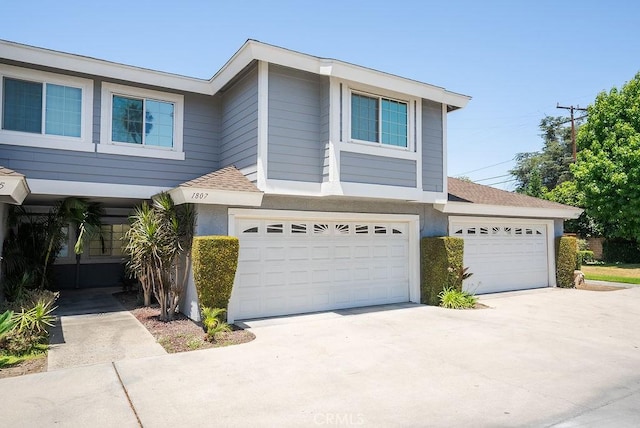 1807 E Cypress St E, Anaheim, CA 92805 - view of front of house featuring roof with shingles, concrete driveway, a garage, and stucco siding
