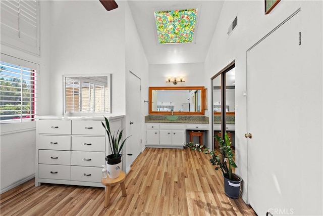 12750 Centralia St Unit 159, Lakewood, CA 90715 - bathroom with wood finished floors, vanity, and a towering ceiling