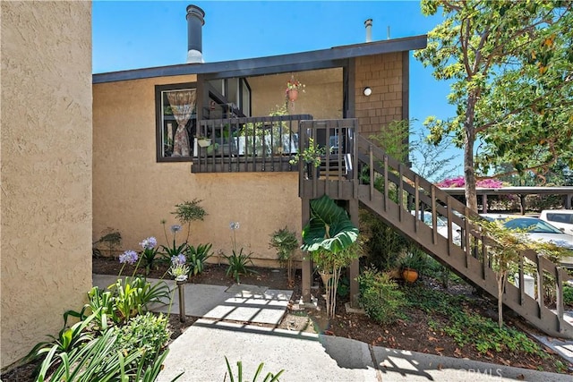 12750 Centralia St Unit 159, Lakewood, CA 90715 - rear view of property featuring stairs and stucco siding