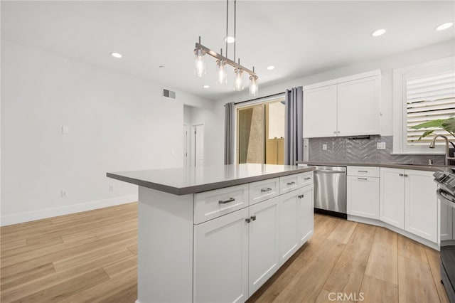 6508 Alondra Blvd, Paramount, CA 90723 - kitchen featuring stainless steel dishwasher, tasteful backsplash, light wood finished floors, recessed lighting, and white cabinets