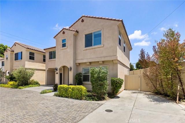 6508 Alondra Blvd, Paramount, CA 90723 - mediterranean / spanish house featuring stucco siding, driveway, a tile roof, and a gate
