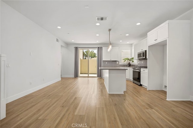 6508 Alondra Blvd, Paramount, CA 90723 - kitchen featuring appliances with stainless steel finishes, open floor plan, backsplash, white cabinets, and recessed lighting