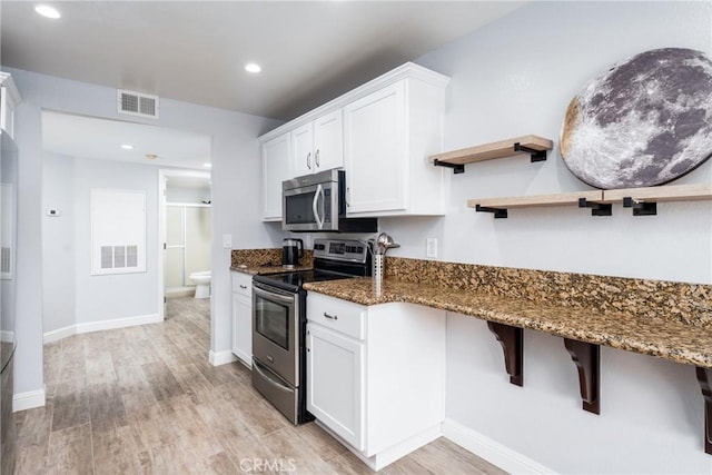 72 Corniche Dr Unit C, Dana Point, CA 92629 - kitchen with appliances with stainless steel finishes, light wood-style floors, dark stone counters, white cabinetry, and recessed lighting