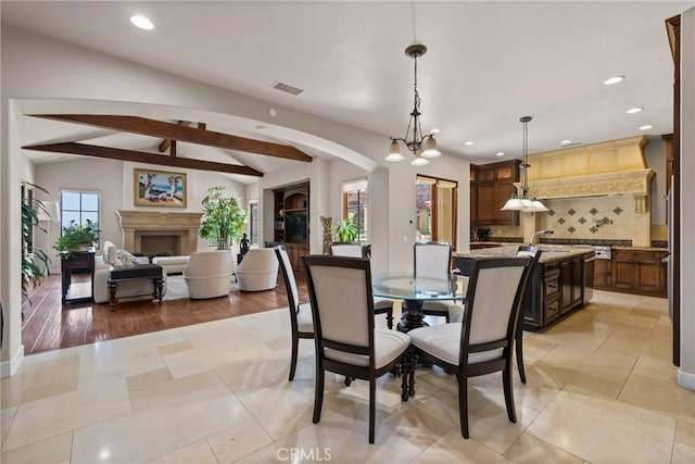 1377 Versante Cir, Corona, CA 92881 - dining space with recessed lighting, a chandelier, arched walkways, and a fireplace