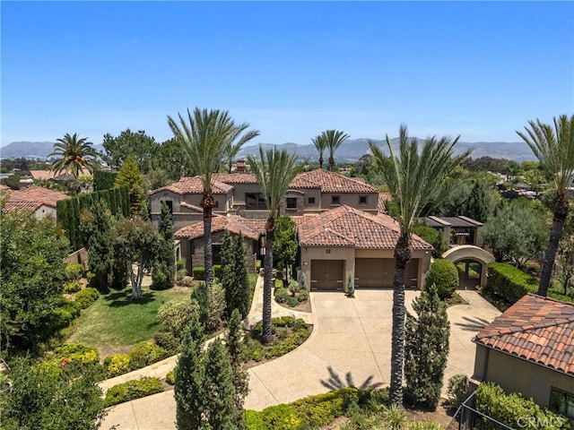1377 Versante Cir, Corona, CA 92881 - mediterranean / spanish-style home featuring driveway, an attached garage, stucco siding, a tiled roof, and a mountain view