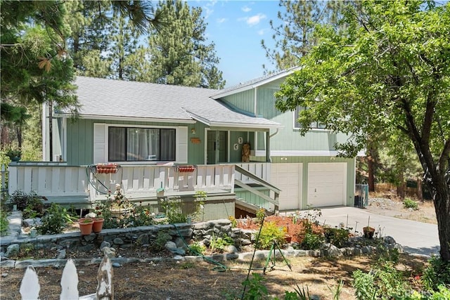 1876 Sparrow Rd, Wrightwood, CA 92397 - split level home with concrete driveway, roof with shingles, a garage, and covered porch