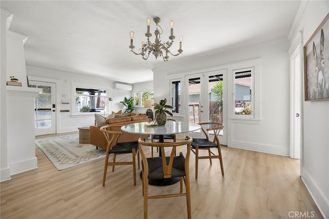 1111 Dawson Ave, Long Beach, CA 90804 - dining area with a wall mounted air conditioner, light wood finished floors, a chandelier, and french doors