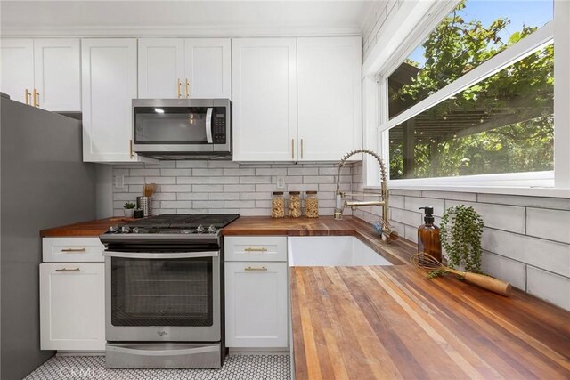 1111 Dawson Ave, Long Beach, CA 90804 - kitchen featuring butcher block counters, stainless steel appliances, decorative backsplash, and white cabinetry