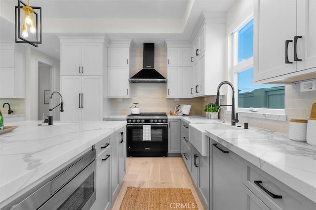 2117 Marshallfield Ln Unit B, Redondo Beach, CA 90278 - kitchen featuring range with gas cooktop, wall chimney exhaust hood, light wood finished floors, and tasteful backsplash