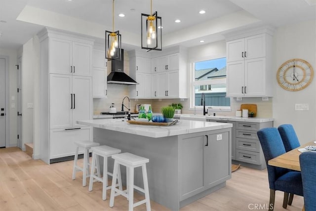 2117 Marshallfield Ln Unit B, Redondo Beach, CA 90278 - kitchen featuring a raised ceiling, wall chimney range hood, light wood finished floors, and recessed lighting