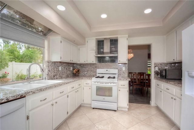 7008 Davenport Ct, Rancho Cucamonga, CA 91701 - kitchen featuring white appliances, wall chimney exhaust hood, backsplash, white cabinets, and a raised ceiling