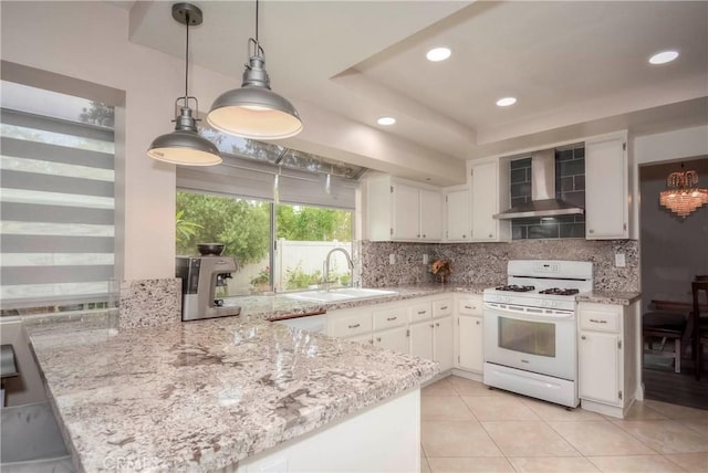 7008 Davenport Ct, Rancho Cucamonga, CA 91701 - kitchen with wall chimney range hood, white gas range oven, tasteful backsplash, a peninsula, and white cabinetry