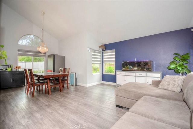7008 Davenport Ct, Rancho Cucamonga, CA 91701 - living room with a chandelier, light wood-style floors, plenty of natural light, high vaulted ceiling, and radiator