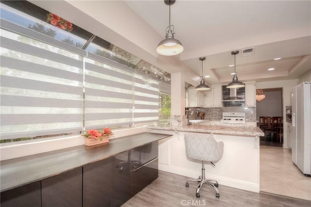 7008 Davenport Ct, Rancho Cucamonga, CA 91701 - kitchen with range, tasteful backsplash, a kitchen bar, white refrigerator with ice dispenser, and hanging light fixtures