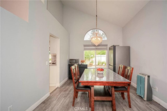 7008 Davenport Ct, Rancho Cucamonga, CA 91701 - dining area with high vaulted ceiling, light wood finished floors, and a chandelier