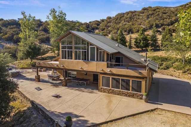 26380 San Felipe Rd, Warner Springs, CA 92086 - rear view of house featuring a patio, a sunroom, stucco siding, and a forest view