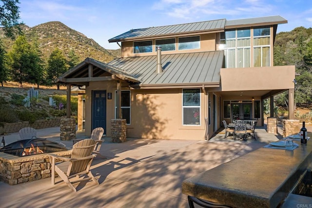 26380 San Felipe Rd, Warner Springs, CA 92086 - rear view of house featuring a standing seam roof, a fire pit, stucco siding, a patio, and a metal roof