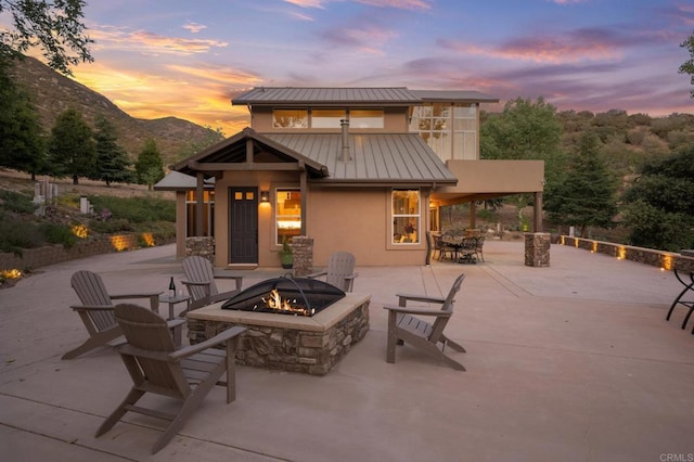26380 San Felipe Rd, Warner Springs, CA 92086 - patio terrace at dusk featuring a fire pit, a mountain view, and a patio