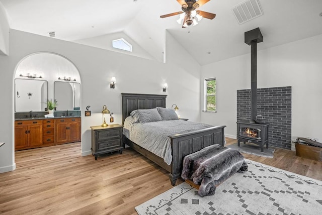 26380 San Felipe Rd, Warner Springs, CA 92086 - bedroom with a wood stove, light wood-type flooring, high vaulted ceiling, connected bathroom, and a ceiling fan