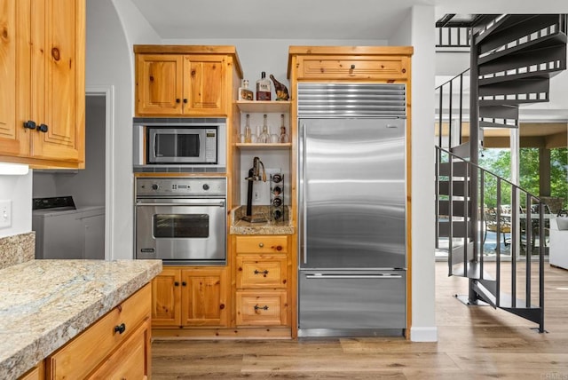 26380 San Felipe Rd, Warner Springs, CA 92086 - kitchen with built in appliances, washing machine and clothes dryer, light wood finished floors, and open shelves