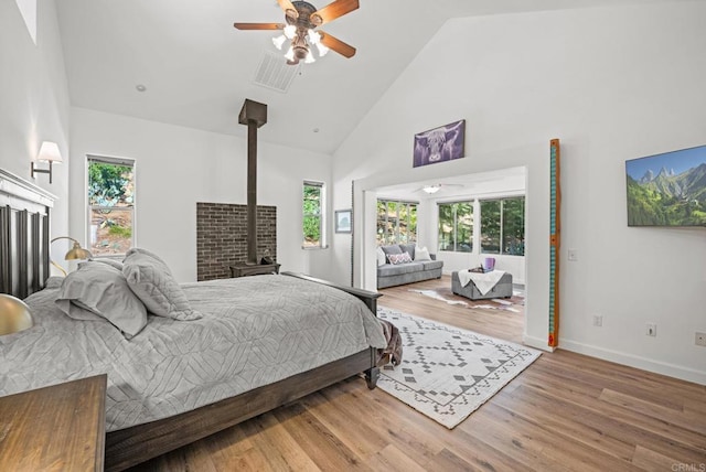 26380 San Felipe Rd, Warner Springs, CA 92086 - bedroom with high vaulted ceiling, a wood stove, multiple windows, and wood finished floors