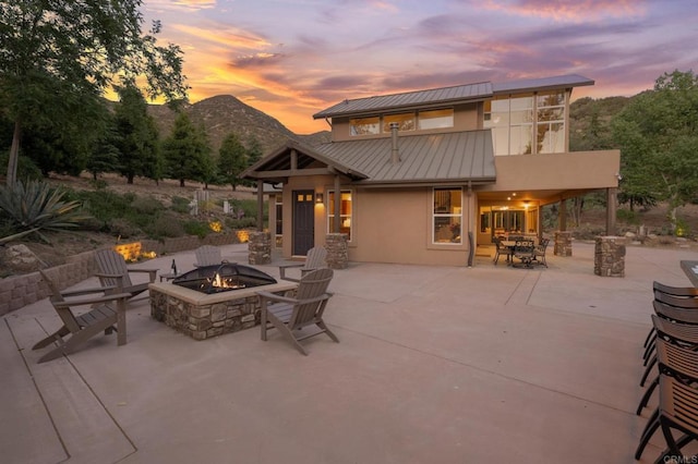 26380 San Felipe Rd, Warner Springs, CA 92086 - patio terrace at dusk featuring an outdoor fire pit, a patio, and a mountain view