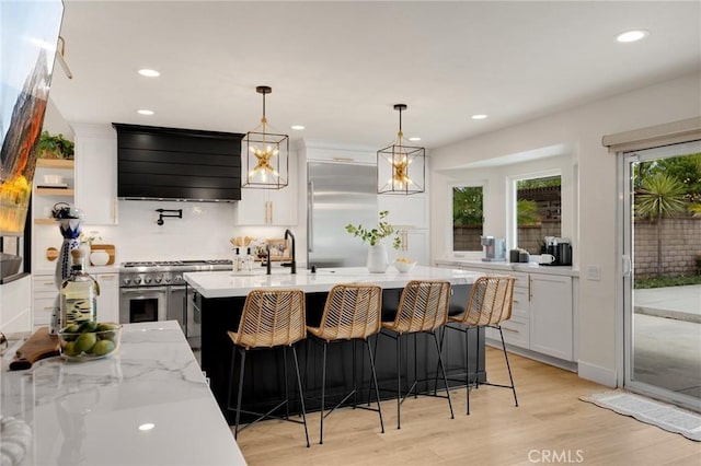 637 Silver Bridle Rd, Walnut, CA 91789 - kitchen featuring extractor fan, high end appliances, white cabinetry, recessed lighting, and light wood-style flooring