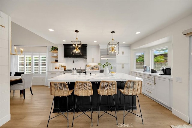 637 Silver Bridle Rd, Walnut, CA 91789 - kitchen with custom range hood, light countertops, light wood finished floors, a chandelier, and recessed lighting
