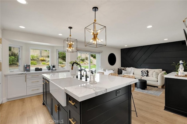 637 Silver Bridle Rd, Walnut, CA 91789 - kitchen with white cabinets, light wood-style floors, hanging light fixtures, recessed lighting, and a kitchen island with sink