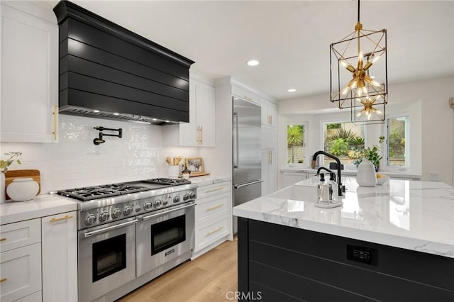 637 Silver Bridle Rd, Walnut, CA 91789 - kitchen with high quality appliances, exhaust hood, a chandelier, white cabinetry, and tasteful backsplash