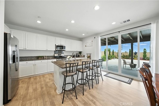 14160 Hercules St, Hesperia, CA 92345 - kitchen featuring stainless steel appliances, white cabinets, light wood-style flooring, a breakfast bar area, and recessed lighting