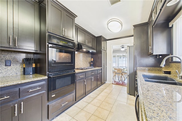 8412 San Marino Dr, Buena Park, CA 90620 - kitchen with appliances with stainless steel finishes, light tile patterned floors, decorative backsplash, under cabinet range hood, and light stone countertops