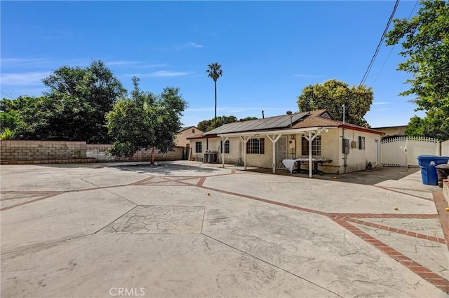 17959 Cantara St, Reseda, CA 91335 - rear view of house with stucco siding, roof mounted solar panels, a fenced backyard, a patio, and a gate