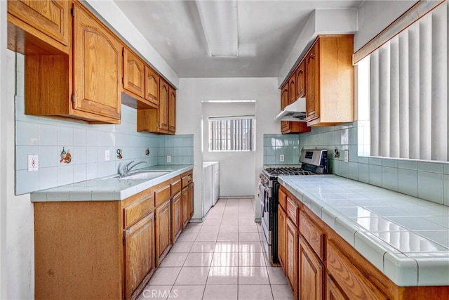 17959 Cantara St, Reseda, CA 91335 - kitchen with stainless steel gas range oven, under cabinet range hood, tasteful backsplash, and tile counters