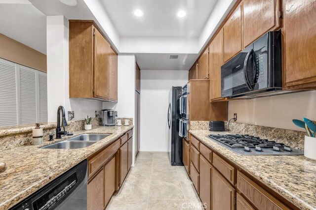 3284 Barham Blvd Unit 201, Los Angeles, CA 90068 - kitchen featuring black appliances, light stone counters, brown cabinets, light tile patterned floors, and recessed lighting