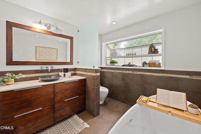 5245 Ramsdell Ave, La Crescenta, CA 91214 - bathroom featuring tile walls, vanity, a bath, tile patterned flooring, and a wainscoted wall