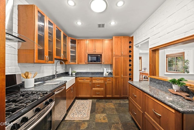 5245 Ramsdell Ave, La Crescenta, CA 91214 - kitchen with appliances with stainless steel finishes, brown cabinets, stone finish flooring, glass insert cabinets, and recessed lighting