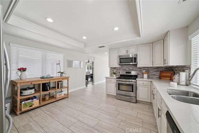 1346 Butler Way, Upland, CA 91786 - kitchen featuring appliances with stainless steel finishes, decorative backsplash, white cabinets, a tray ceiling, and ornamental molding